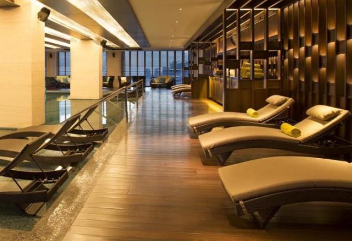 The Westin Jakarta gay-friendly hotel's pool area. Lounge chairs line the pool. Wood floors and modern decor. Great for gay travel.