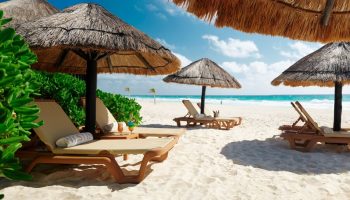 Beachfront at The Westin Lagunamar Ocean Resort Villas & Spa Cancun, a gay-friendly hotel. Lounge chairs under thatched umbrellas.