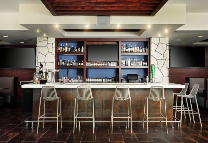 Bar area at The Westin Lagunamar Ocean Resort Villas & Spa Cancun. Gay-friendly hotel bar with stools, drinks, and TVs. Cancun travel.
