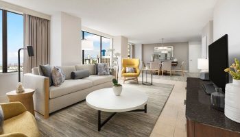 The Westin Long Beach gay-friendly hotel suite: living area with sofa, chairs, table, city view. Ideal for LGBT travelers' comfort.