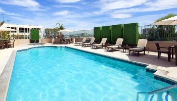 The Westin Long Beach gay-friendly hotel pool. Outdoor pool with lounge chairs, tables, & umbrellas. Perfect for gay men's travel.