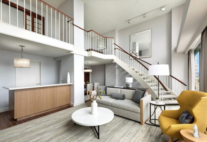 The Westin Long Beach gay-friendly hotel suite. Living room with stairs, sofa, yellow chair, and modern decor. Upscale travel for gay men.