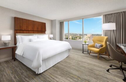 The Westin Long Beach gay-friendly hotel room. King bed, city view, yellow chair, desk. Modern, comfortable, and inviting space.