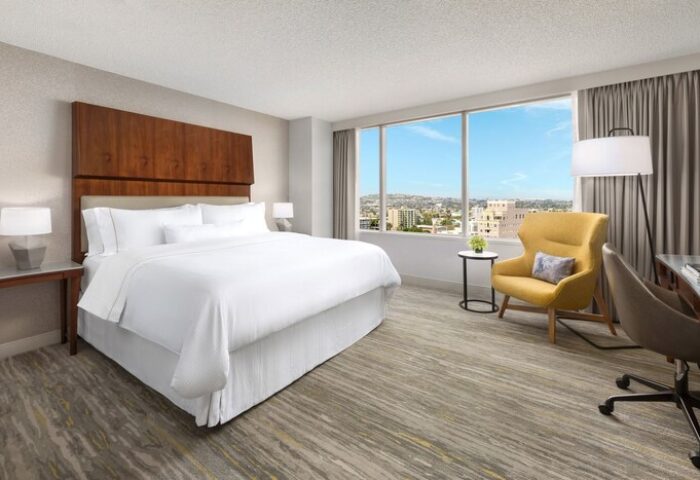 The Westin Long Beach gay-friendly hotel room. King bed, city view, yellow chair, desk. Modern, comfortable, and inviting space.