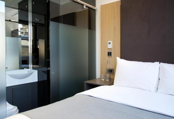 The Z Hotel City room. Modern gay-friendly hotel room with bed, frosted glass bathroom, and sleek design. Ideal for gay travel in the city.