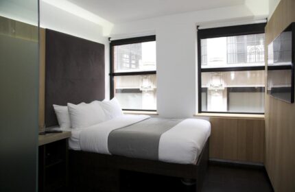 Gay-Friendly Hotel The Z Hotel City: Minimalist room with double bed, large headboard, and two windows. Modern design, ideal for gay travelers.