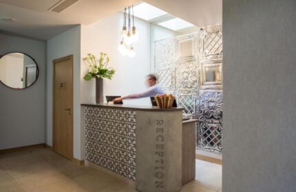 The Z Hotel City reception area. Gay-friendly hotel with a modern design, featuring a stylish reception desk and decorative wall panels.