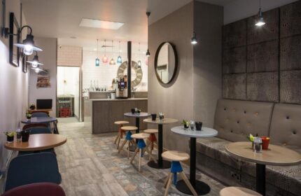 The Z Hotel City's stylish interior. Gay-friendly hotel with modern design, featuring tables, chairs, and a cozy seating area. Ideal for gay travel.