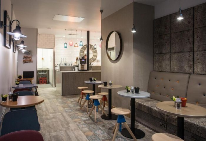The Z Hotel City's stylish interior. Gay-friendly hotel with modern design, featuring tables, chairs, and a cozy seating area. Ideal for gay travel.