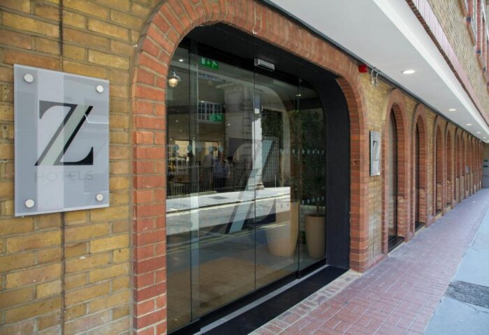 The Z Hotel Piccadilly entrance. Gay-friendly hotel with brick facade and glass doors. Z Hotels logo visible. A great choice for gay travel.