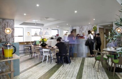 The Z Hotel Piccadilly's interior. A gay-friendly hotel with a reception desk, dining area, and modern design. Ideal for gay men's travel.