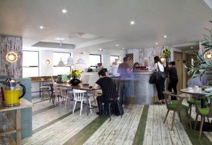 The Z Hotel Piccadilly's interior. A gay-friendly hotel with a reception desk, dining area, and modern design. Ideal for gay men's travel.