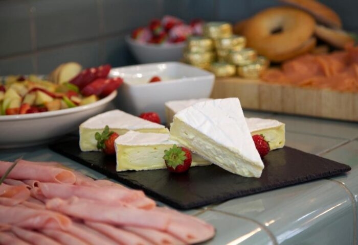 Buffet at The Z Hotel Piccadilly, a gay-friendly hotel. Brie, strawberries, ham, and bagels offer a delicious dining experience.
