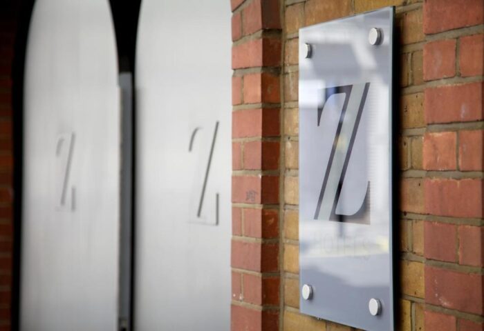 The Z Hotel Piccadilly entrance. Gay-friendly hotel sign on a brick wall. The Z Hotels logo is visible. Gay travel advice in London.