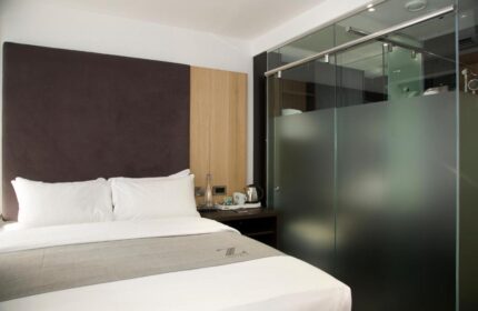 The Z Hotel Piccadilly room. Modern gay-friendly hotel room with bed, glass shower, and minimalist design. Perfect for gay travel in London.