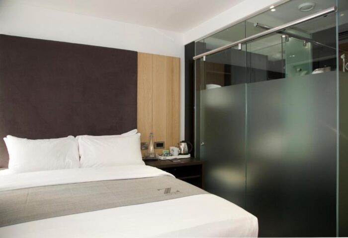 The Z Hotel Piccadilly room. Modern gay-friendly hotel room with bed, glass shower, and minimalist design. Perfect for gay travel in London.