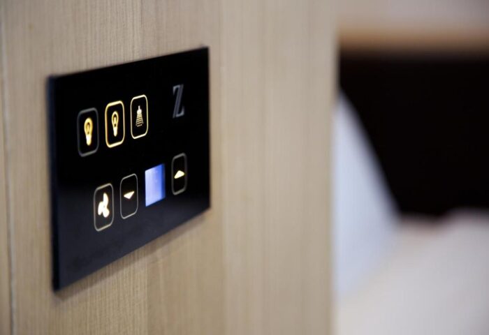 Room controls at The Z Hotel Shoreditch, a gay-friendly hotel. Features lighting, shower, fan, and temperature adjustment. Modern design.