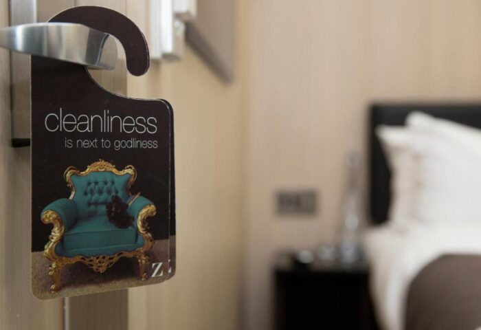 The Z Hotel Shoreditch's door hanger: Cleanliness is next to godliness. Gay-friendly hotel room detail. Shoreditch, London.