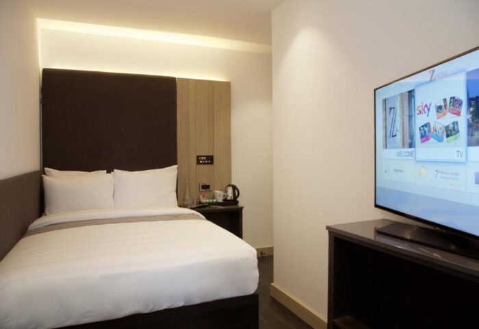 Bedroom at The Z Hotel Shoreditch, a gay-friendly hotel. Features a double bed, TV, and modern decor. Ideal for gay men's travel in Shoreditch.