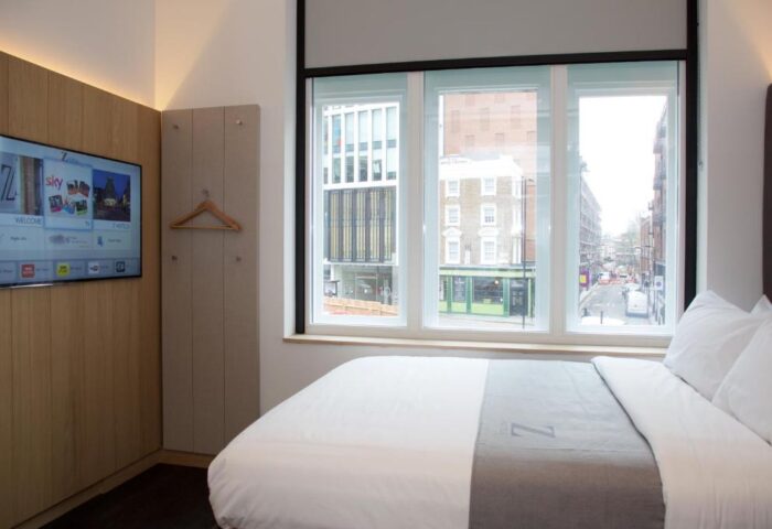 The Z Hotel Shoreditch room. Gay-friendly hotel with a TV, bed, and window view of the city street. Modern interior design. Shoreditch, London.