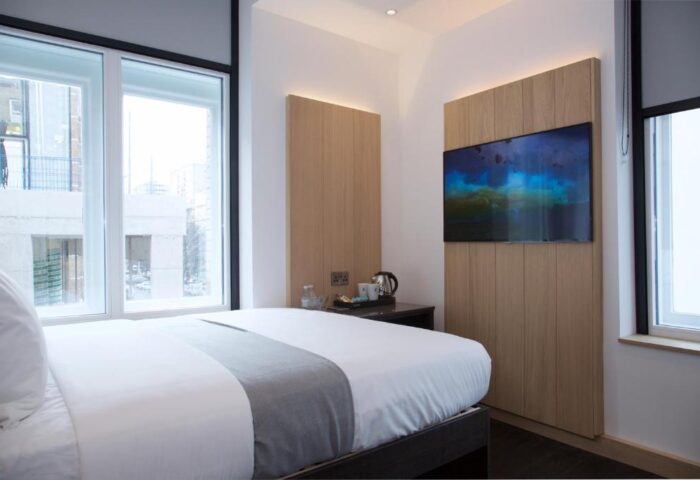 The Z Hotel Shoreditch room interior. Gay-friendly hotel with modern design, featuring a comfy bed, TV, and city view. Ideal for gay travelers.