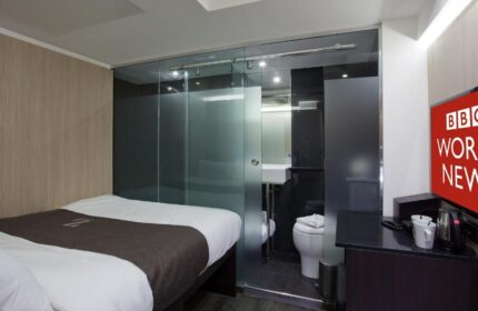 The Z Hotel Soho room: bed, glass-enclosed bathroom. Modern, compact design. Gay-friendly hotel in London. Ideal for gay travel.