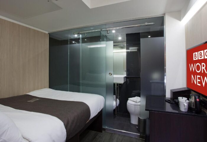The Z Hotel Soho room: bed, glass-enclosed bathroom. Modern, compact design. Gay-friendly hotel in London. Ideal for gay travel.