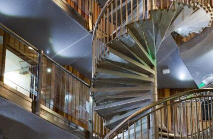 Interior of The Z Hotel Soho, a gay-friendly hotel. Features a spiral staircase with metal railings and wooden walls. Modern design.