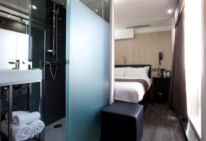 The Z Hotel Soho room. Modern bathroom with shower and frosted glass next to the bed. Gay-friendly hotel in London's Soho.