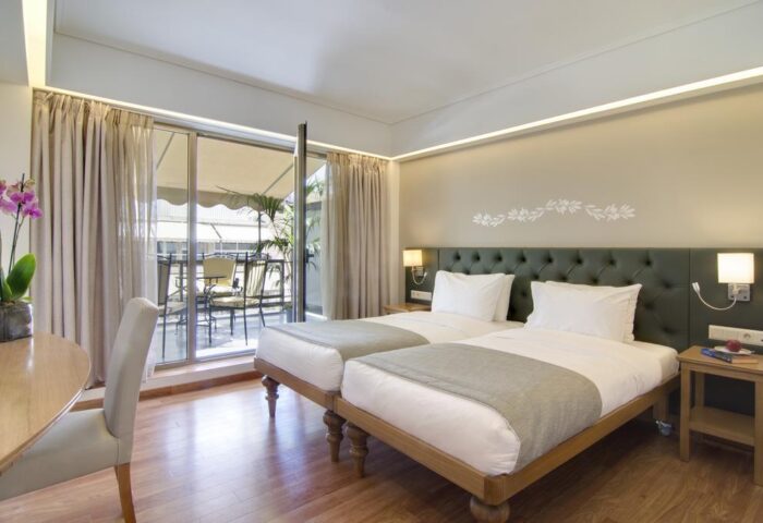 Titania Hotel gay-friendly room with twin beds, desk, and balcony. Comfortable lodging for gay travelers. Stylish Athens hotel.