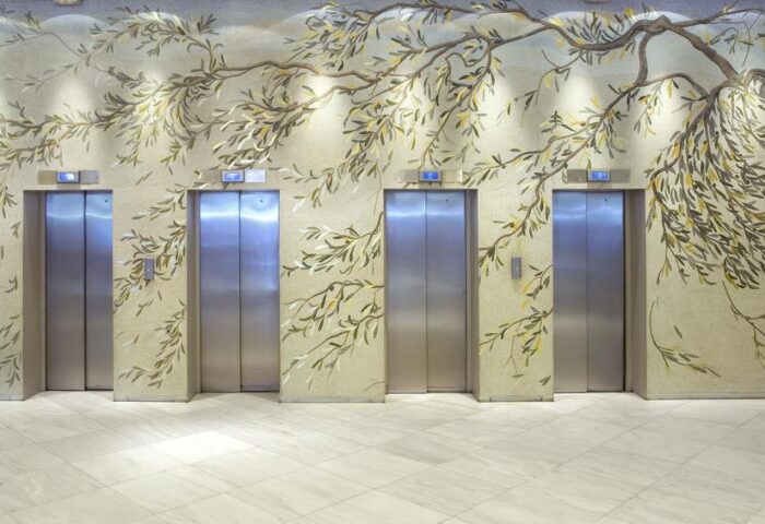 Titania Hotel's gay-friendly design: Four elevators with a tree branch mural. A modern, stylish touch for gay men travelers.