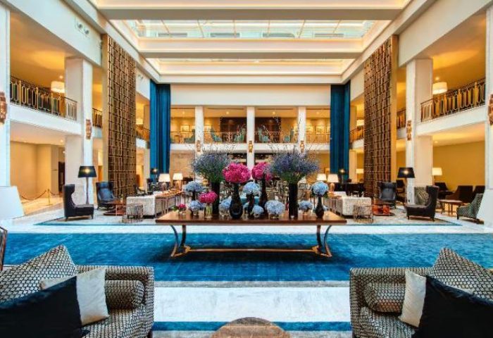 Tivoli Avenida Liberdade, a gay-friendly hotel: grand lobby with blue accents, flowers, and seating. Leading Hotels of the World.