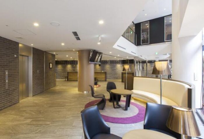 Tokyu Stay Shinjuku lobby. Gay-friendly hotel with modern seating, reception desk, and elevator. Ideal for gay travel in Shinjuku, Japan.
