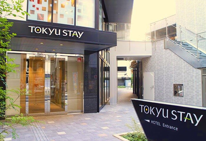 Tokyu Stay Shinjuku entrance. Gay-friendly hotel in Shinjuku, Japan. Modern building with glass doors and a sign indicating the hotel entrance.