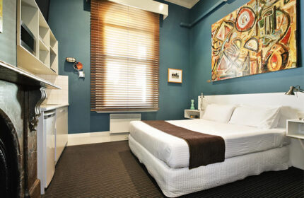 Tolarno Hotel room. Gay-friendly hotel with bed, art, kitchenette, and window. Modern design in a boutique hotel. Gay travel lodging.