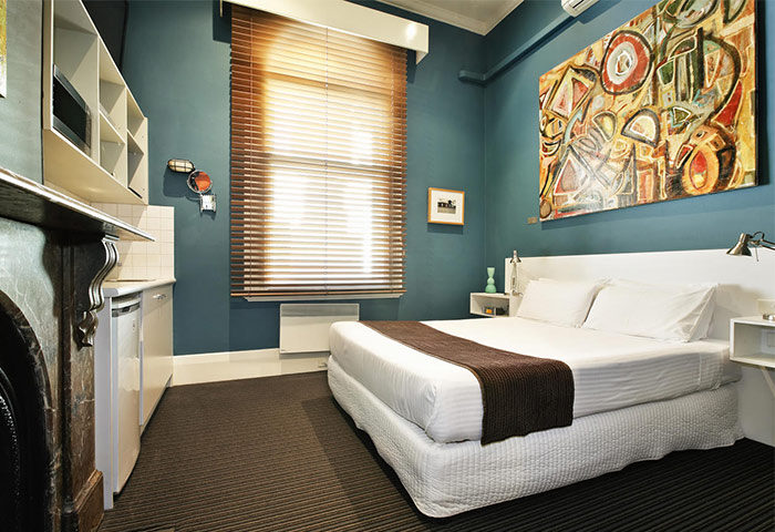 Tolarno Hotel room. Gay-friendly hotel with bed, art, kitchenette, and window. Modern design in a boutique hotel. Gay travel lodging.