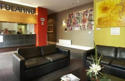 Tolarno Hotel lobby area. Gay-friendly hotel with modern decor, black leather sofas, and artwork. A welcoming space for gay travelers.