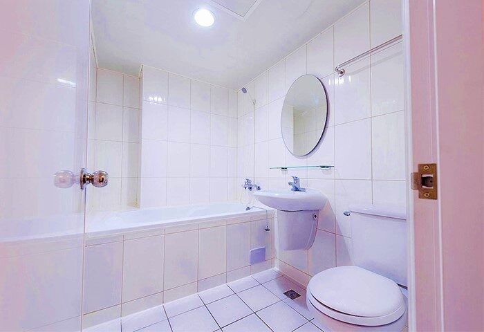 Tomorrow Hotel bathroom. Clean, white tiled bathroom with tub, toilet, and sink. Gay-friendly hotel for gay men travel.
