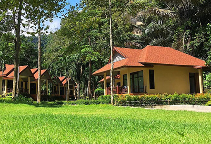 Tonsai Bay Resort: Gay-friendly hotel bungalows with red roofs, set in lush greenery. A relaxing vacation spot for gay travelers.