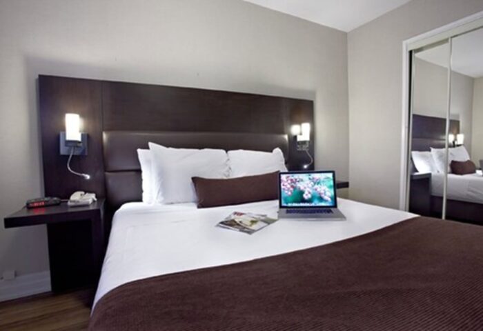 Town Inn Suites gay-friendly hotel room. Modern design with a laptop on the bed. Comfortable accommodations for gay travelers.