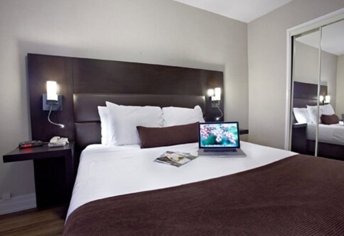 Town Inn Suites gay-friendly hotel room. Modern design with a laptop on the bed. Comfortable accommodations for gay travelers.