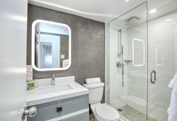 Town Inn Suites gay-friendly hotel bathroom. Modern design with illuminated mirror, glass shower, & sleek fixtures. Ideal for gay travel.
