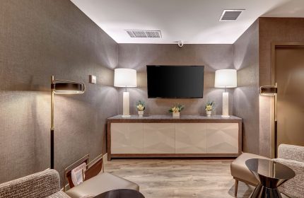 Town Inn Suites, a gay-friendly hotel. Modern hotel lounge area with TV, lamps, seating, and contemporary design. Ideal for gay travelers.