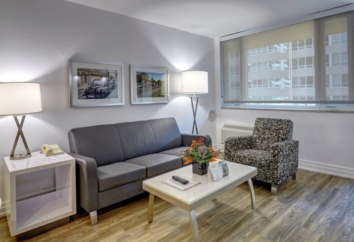 Town Inn Suites, a gay-friendly hotel: Suite living area with sofa, chair, table, and city view. Ideal for gay men's travel.