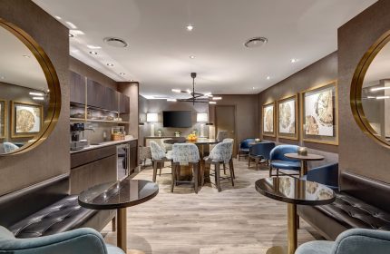 Town Inn Suites, a gay-friendly hotel: modern lounge area with tables, chairs, and a kitchenette, perfect for relaxing.