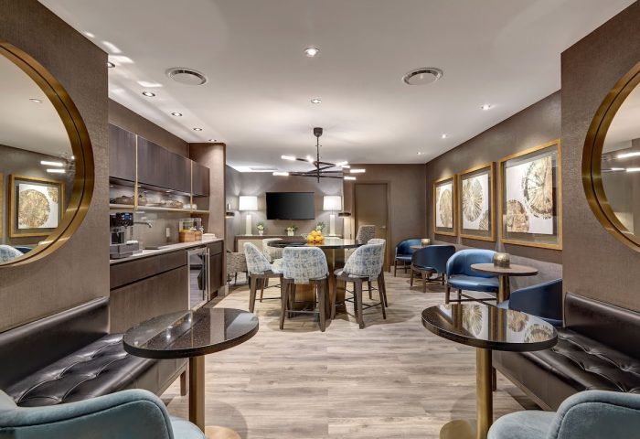 Town Inn Suites, a gay-friendly hotel: modern lounge area with tables, chairs, and a kitchenette, perfect for relaxing.