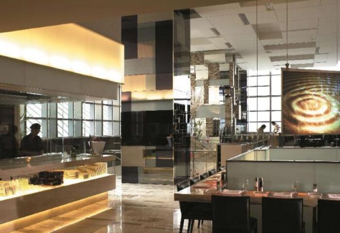 Interior of Traders Hotel Kuala Lumpur, a gay-friendly hotel. Modern design with dining area, open kitchen, and stylish decor.