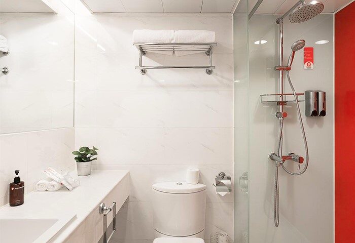 Bathroom at Travelodge Central Hollywood Road, a gay-friendly hotel. Features a shower, toilet, sink, and amenities for a comfortable stay.