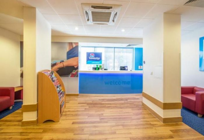 Travelodge London Central Southwark lobby. Gay-friendly hotel with a bright blue reception desk and welcoming atmosphere. Ideal for gay travelers.