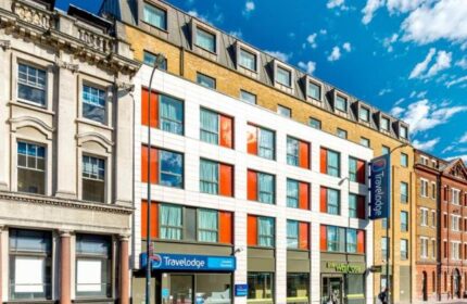 Travelodge London Vauxhall exterior. Gay-friendly, pet-friendly hotel. Modern facade with blue Travelodge sign, near Waitrose.